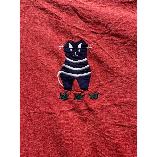 This vibrant vintage African textile bursts with joyful charm and cultural craftsmanship. Set against a bold red...