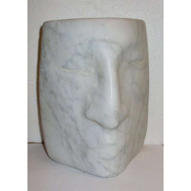 Smooth block of what Carrera Marble with fine grey veins throughout. Face seem as almost emerging from a triangular corner...