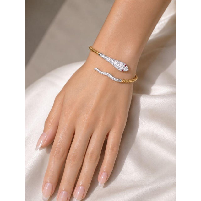 Beautiful estate bangle bracelet crafted in 14K yellow gold, featuring a striking snake design adorned with brilliant...