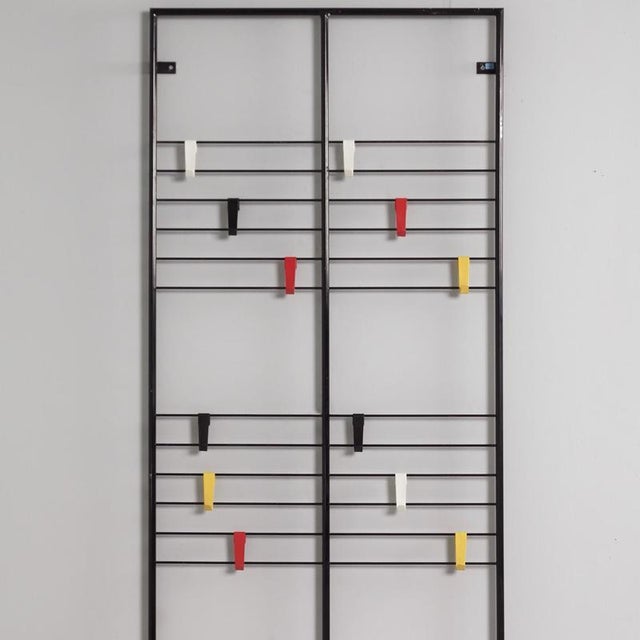 Gw1 wall-mounted coat rack by coen de vries, designed in 1954. The rhythmic interplay of the black tubular steel frame and...