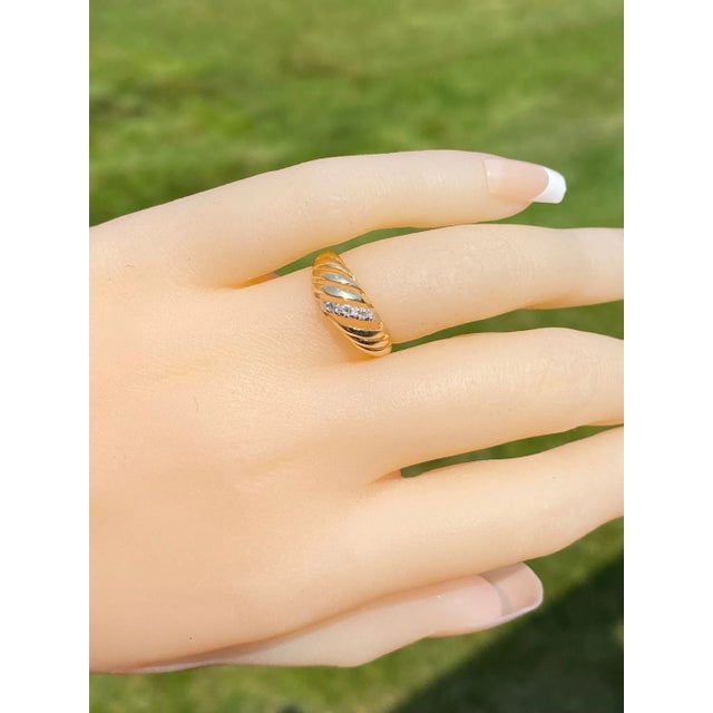 The Henderson: Yellow Gold Waved Cocktail Ring with Diamonds. The ring centers on a row of round brilliant cut diamonds in...