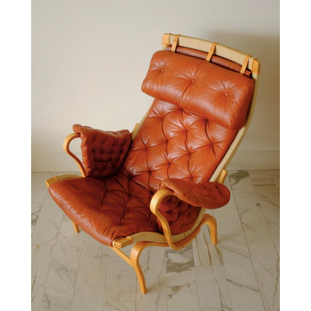 The classic Pernilla chair by Bruno Mathsson for DUX. Beech frame and brown/red leather and beige canvas upholstery with...