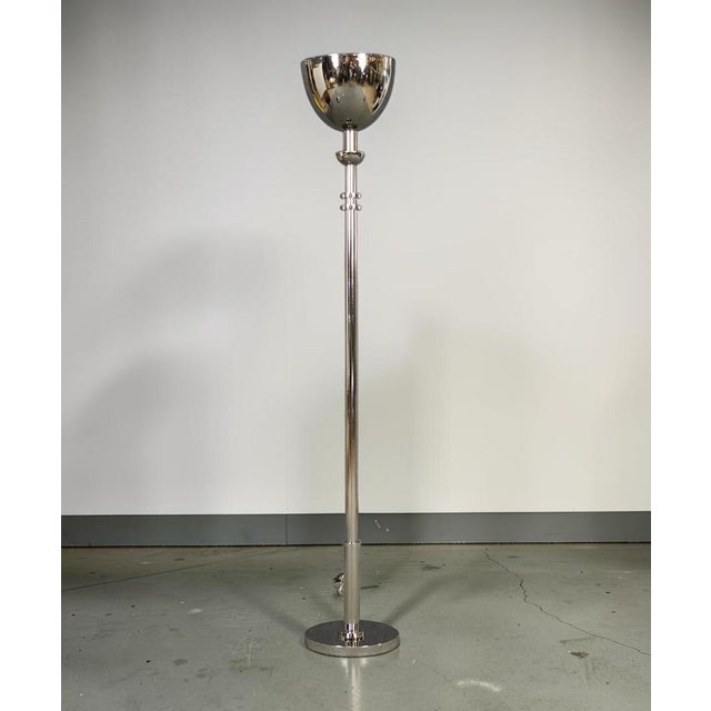 A striking pair of Ralph Lauren Home polished chrome torchiere floor lamps featuring sleek cylindrical stems, substantial...