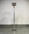 A striking pair of Ralph Lauren Home polished chrome torchiere floor lamps featuring sleek cylindrical stems, substantial...
