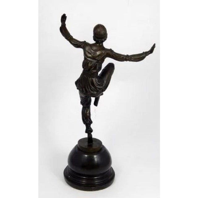 This original Art Deco bronze sculpture depicts a female dancer captured mid-motion in a pose with outstretched arms and...