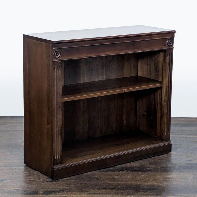 This Ethan Allen bookshelf features a rich dark wood finish with elegant carved details on the sides and corners. It has...