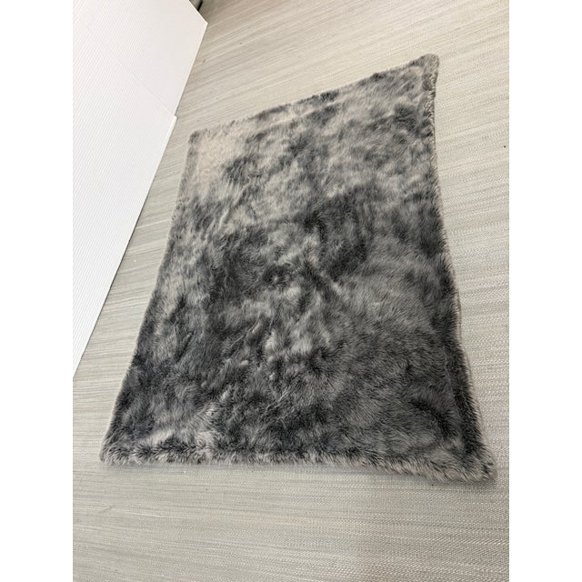 Design Plus Gallery presents a Faux-Fur Throw Blanket a Restoration Hardware. This rectangular throw displays a tonal gray...