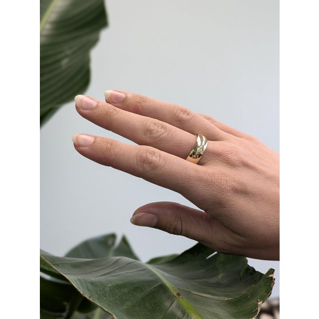 A sleek, timeless band crafted in rich 14k yellow gold with a smooth half-round profile. Designed with a comfort-fit...