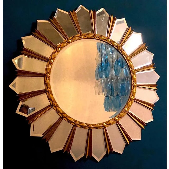 Beautiful gilt sunburst mirror, with a round mirrored glass center in moulded frame. Measures: Diameter 100cm It is a...