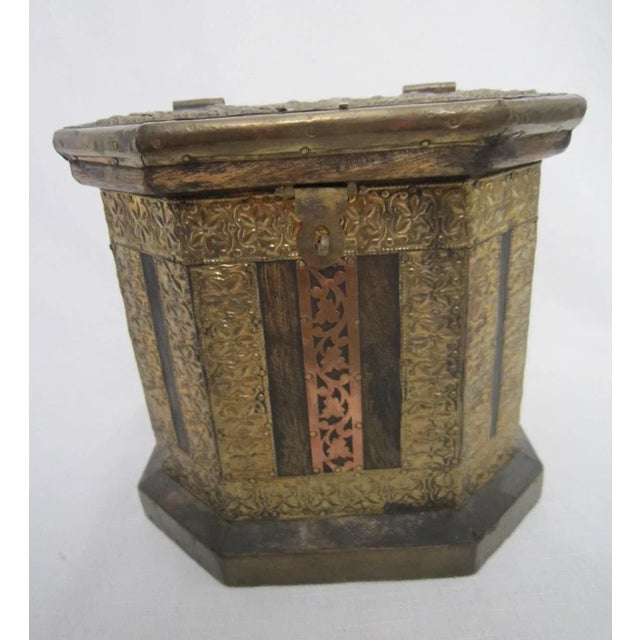 Charming wood box from 60's embellished with brass and copper metal work. Lid opens from the top and has a hook.