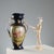 Cobalt blue porcelain vase decorated with gold details. The reserve features a painted everyday scene in a home garden...