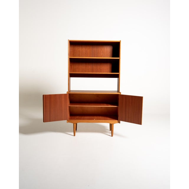 Scandinavian bookcase from the 1950s and 1960s, crafted from teak with oak inserts. The structure is composed of two...