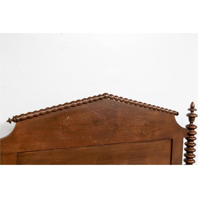 A vintage Jenny Lind style bobbin-turned wooden bed frame with tall posts spool-and-bobbin turned post with acorn finials,...