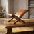 A beautifully shaped vintage footstool featuring warm brown leather upholstery and a sculptural wooden frame. Its curved...