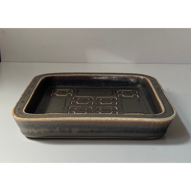 A square dish in earthy solfatara glazes. Designed by the danish ceramist valdemar petersen and manufactured by b&g during...