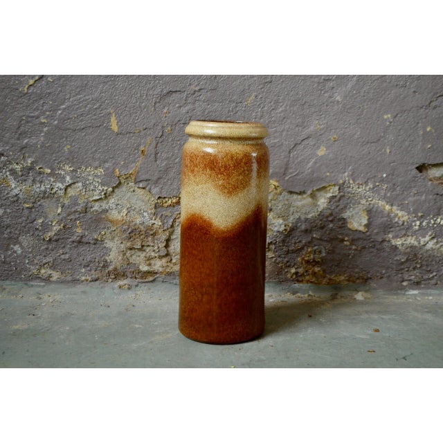 This large vintage vase is a German production from the 60s. Roll-shaped, it is enamelled in beige, raw earth tones....