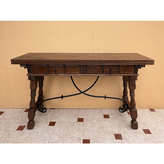 Spanish drop-leaf console table dating from the 1940s. Crafted in wood, it features two front drawers, turned legs, and...