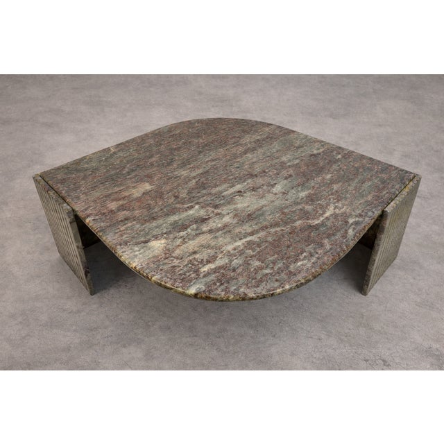 A sculptural stone coffee table, dating from the late 20th century, featuring an elegant eye-shaped top carved from richly...