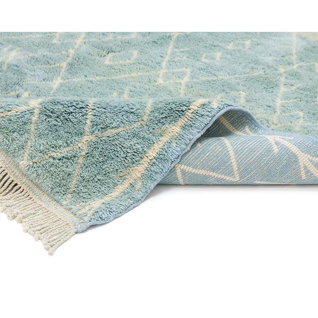 A fine diamond trellis in teal fades gently into pale sage, as though the pattern itself were dissolving into mist across...