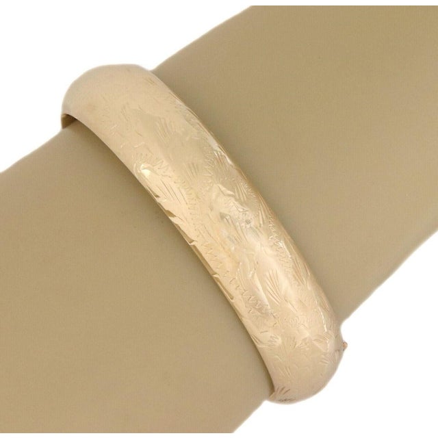 This authentic estate wide band bangle bracelet is crafted in solid 14k yellow gold with a glossy polished finish. The...