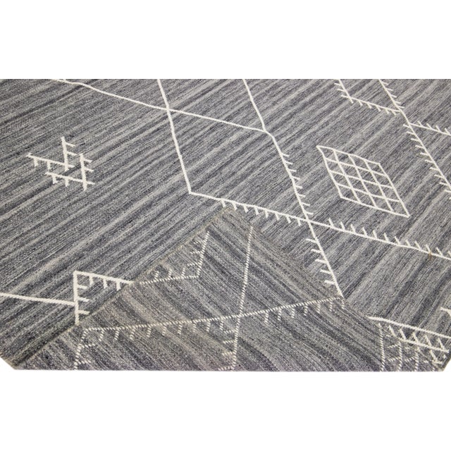 Beautiful kilim handmade wool rug with a gray field. This custom modern flatweave rug of our Nantucket collection has...