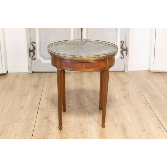 This elegant French bouillotte table, crafted in the early 20th century, embodies the timeless sophistication of the Louis...