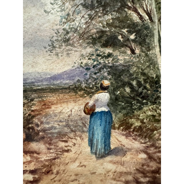 Original watercolor on paper depicting a solitary woman walking along a rustic country path beneath tall trees, with...