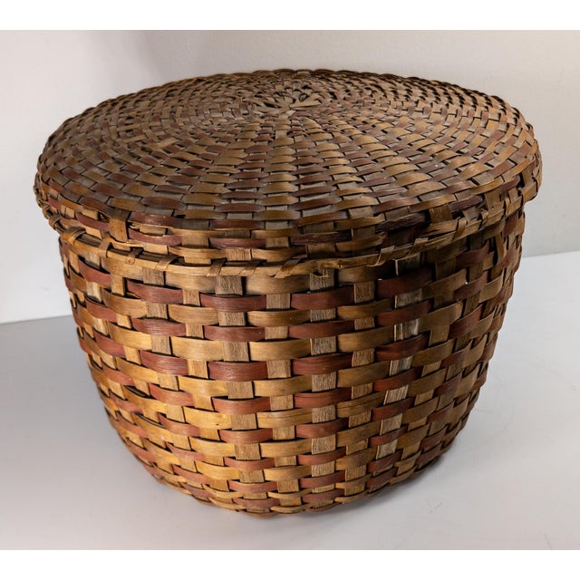 We are offering this large covered Northeast Indian basket. This basket has polychrome woven splint design, probably ash,...