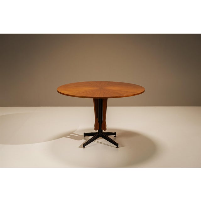 A composition of warm wood tones, geometric detailing and an architectural base, this round dining table attributed to...