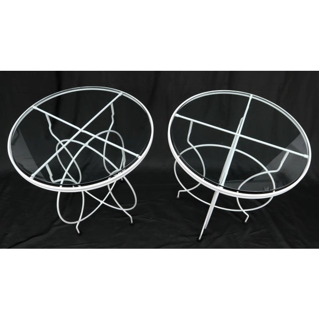 Pair of Mid-Century Modern round wire base folding cafe tables with glass tops on ball feet.