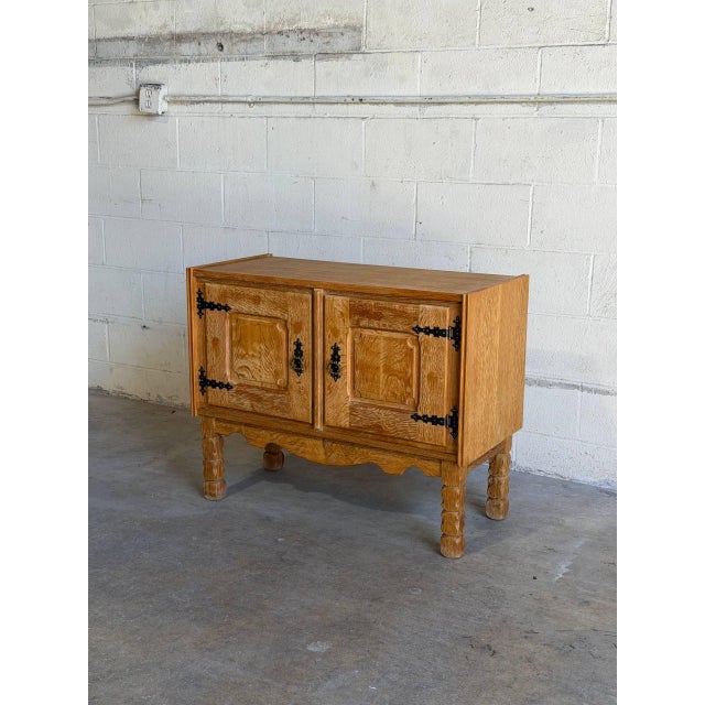 Beautiful vintage Danish oak cabinet in the style of Henning Kjærnulf, featuring rich solid oak grain, hand-carved...