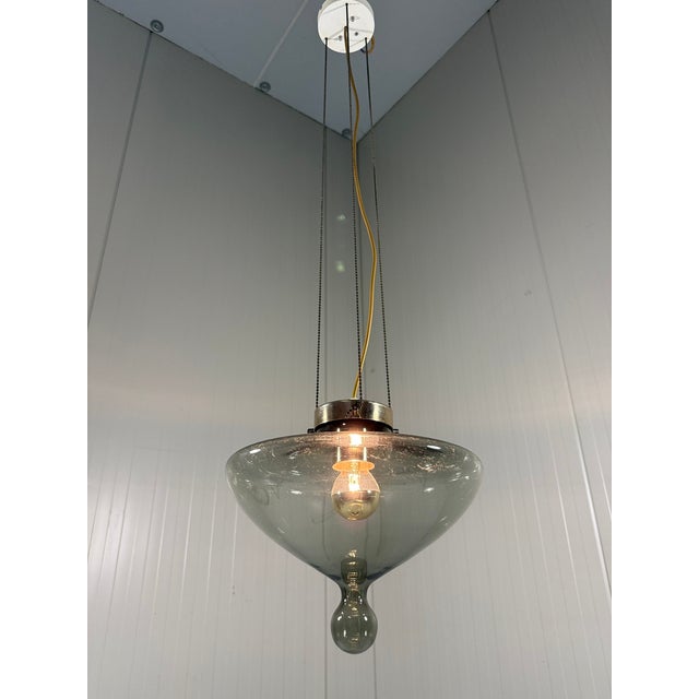 Hanging lamp High Chapparal by Raak Amsterdam, Netherlands (marked). Grey smoked glass shade with a brass cover, 3 small...