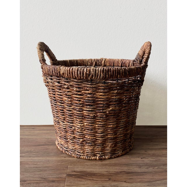 A substantial, handwoven wicker basket with an internal iron wire frame for structural integrity. Originally used in a Los...