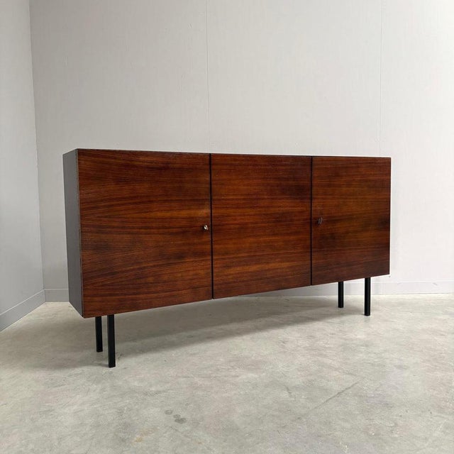 Remarks: Vintage sideboard / highboard by Musterring, German design 1960s. Dark wood veneer on steel legs and with steel...
