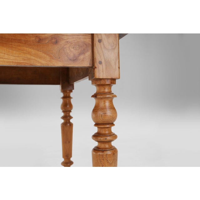 A soulful example of 19th‑century French rural craftsmanship, this elm wood dining table from around 1850 embodies the...