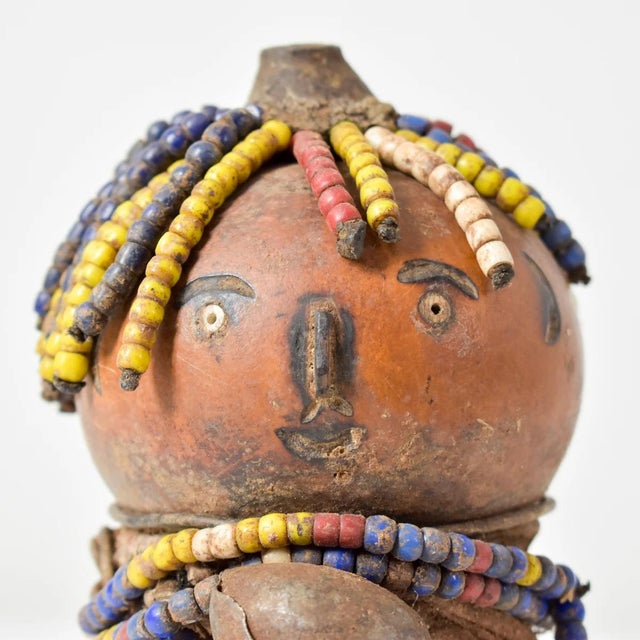 The Nyamwezi Beaded Fertility Doll Gourd with Shells from Tanzania is a stunning representation of fertility and...