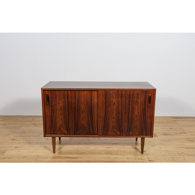 A small sideboard made of rosewood made in the 1960s in Denmark. Sideboard opened with a two sliding doors.The sideboard...