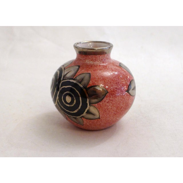 Small Art Deco vase, rounded body and small cylindrical neck with a silver rim, speckled pink background and stylized...