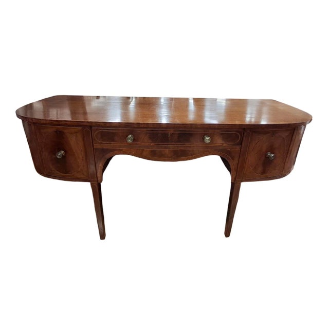 George III inlaid mahogany demilune sideboard. Front center drawer above the serpentine shaped apron, two deep drawers,...