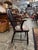 This authentic antique fireside chair features a high, hooped backrest centered by an iconic, hand-pierced "wheelback"...