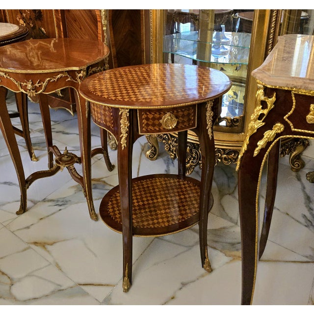 Elegant and richly detailed, this French Louis XV-style accent table showcases exceptional decorative woodworking and...