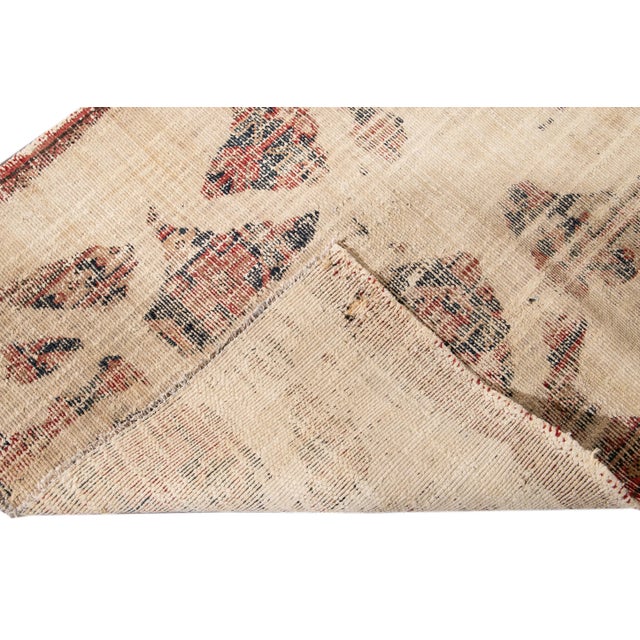 Beautiful hand-knotted, antique vintage wool runner. This rug has an ivory field with an abstract multicolored design....