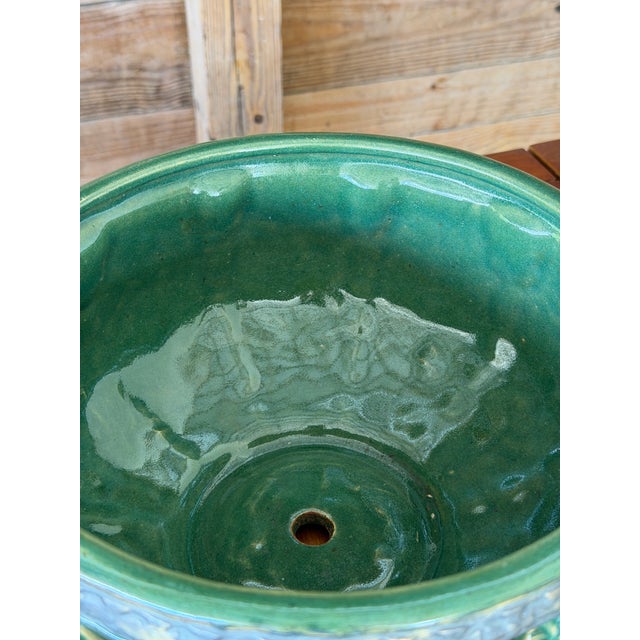 A striking pair of early 20th century green glazed garden planters featuring a beautifully sculptural leaf motif in high...