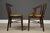 A set of five mid century modern Danish style dining chairs constructed of solid wood in a mahogany color finish. Some...
