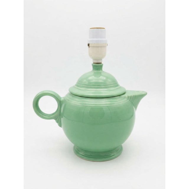 A cheerful matching pair of vintage green ceramic lamps formed as classic teapots, complete with lids, rounded bodies,...