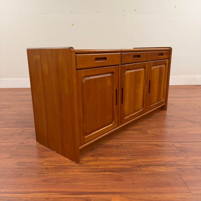 Vintage Danish teak sideboard offering lots of storage space in a clean, functional piece. Design cues include rounded...