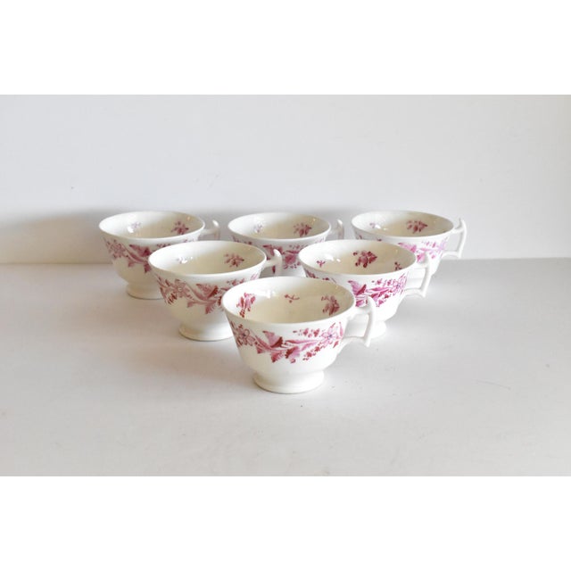 A rare collection of 6 matching Georgian soft paste teacups with London handles and pedestal bases. Hand-painted with pink...