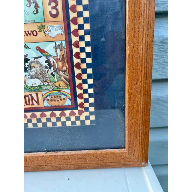 A stylized, folk-art representation of Noah's Ark, featuring alphabet and numerical samplers ("ABC • 123") alongside...