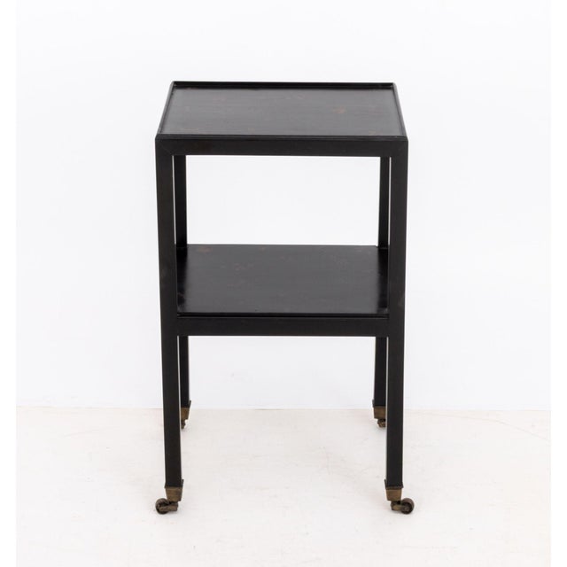 Chinoiserie Style Gilt and Black Lacquered End Table, with floral motif decoration and two tiers above casters. 27" H x...