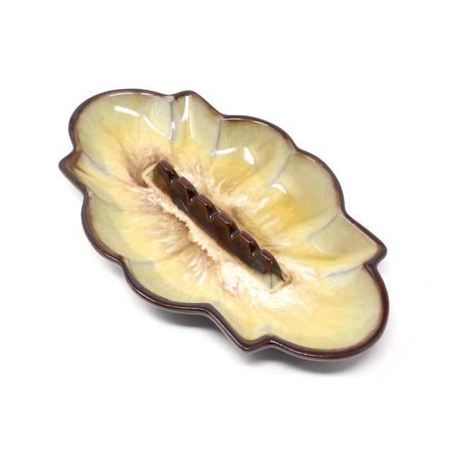 A vintage, ceramic ashtray, with yellow, white and beige drip glaze, and solid brown on the bottom side. Good condition.